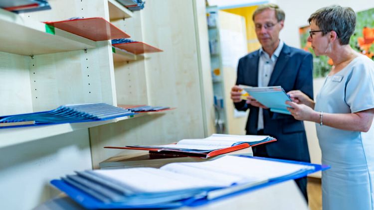 Chefarzt Psychosomatik und Therapeutin besprechen Patientenakten