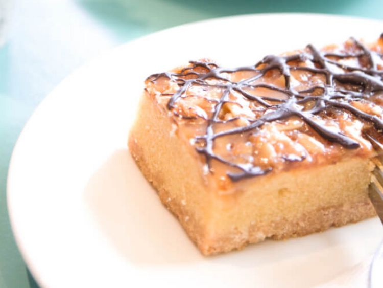 eine Tasse Kaffee neben einem Stück Blechkuchen
