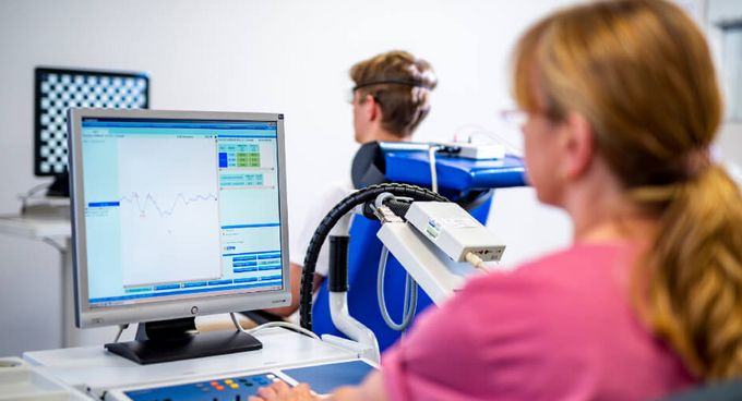 Diagnostik Pflegekraft misst visuell evozierte Potentiale bei einem neurologischen Patienten
