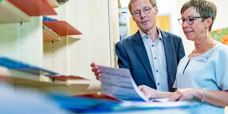 Chefarzt Psychosomatik und Therapeutin blättern in Patientenakten