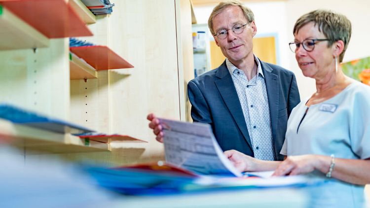 Chefarzt Psychosomatik und Therapeutin blättern in Patientenakten