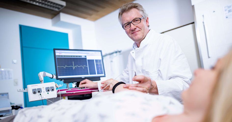 Arzt untersucht Patientin in der Elektromyographie