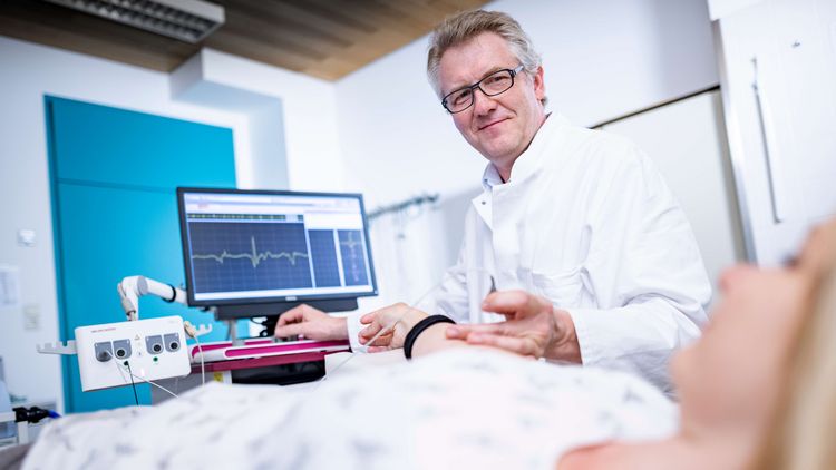 Arzt untersucht Patientin in der Elektromyographie