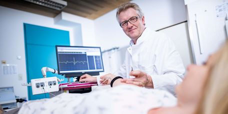 Arzt untersucht Patientin in der Elektromyographie