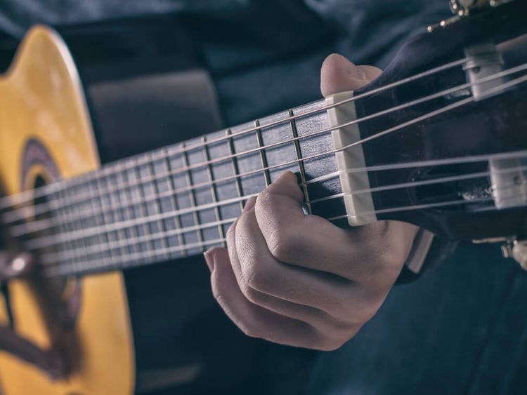 ein Mann spielt Gitarre auf der Bühne