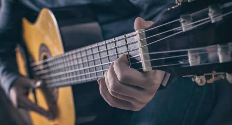 ein Mann spielt Gitarre auf der Bühne