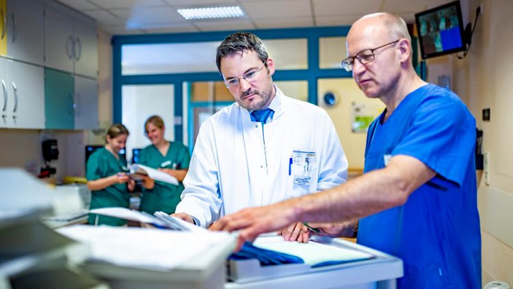 Arzt und Pflegkraft besprechen eine Patientenakte