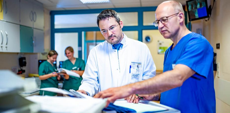 Arzt und Pflegkraft besprechen eine Patientenakte