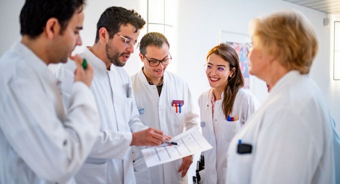 Ärztinnen und Ärzte besprechen gemeinsam einen Tabelle