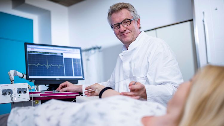 Arzt untersucht Patientin in der Elektromyographie