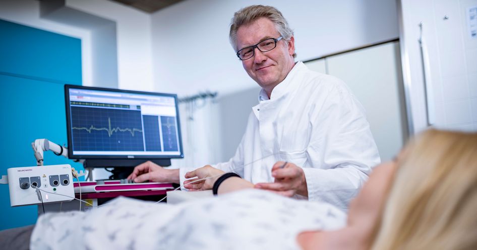 Arzt untersucht Patientin in der Elektromyographie