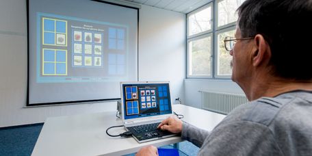 Patient macht bei Gedächtnistraining eine Übung am PC