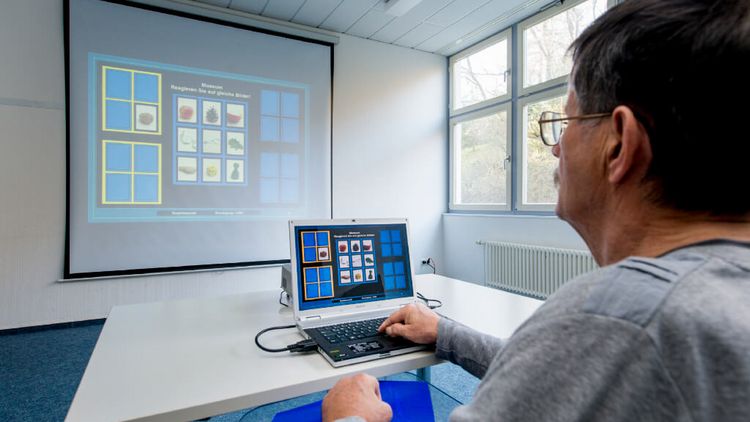 Patient macht bei Gedächtnistraining eine Übung am PC