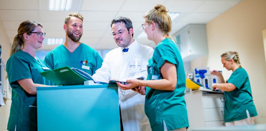 Chefarzt und Pflegekräfte besprechen eine Patientenakte