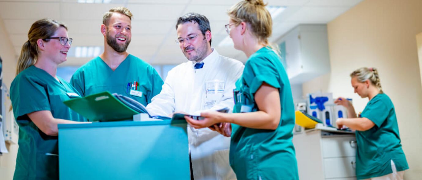 Chefarzt und Pflegekräfte besprechen eine Patientenakte