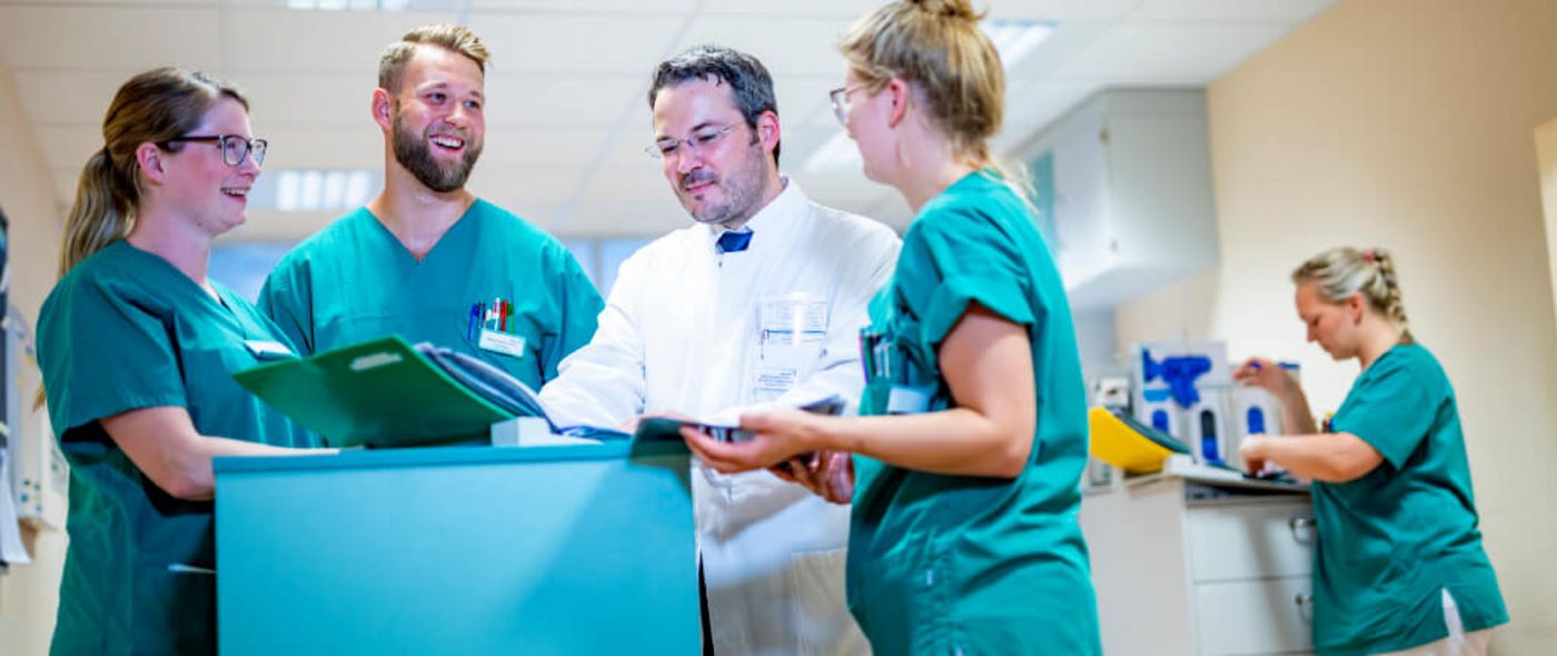 Chefarzt und Pflegekräfte besprechen eine Patientenakte