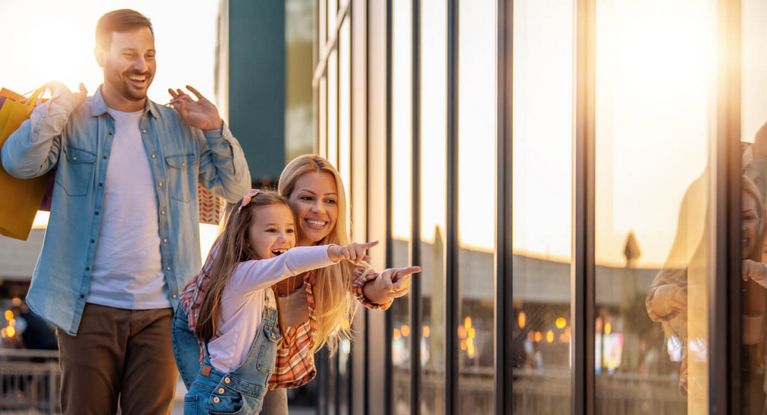Familie mit kleiner Tochter beim Windowshopping
