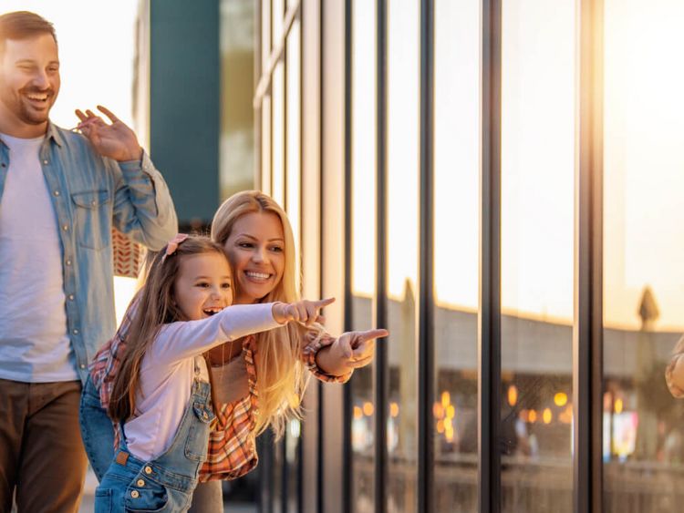 Familie mit kleiner Tochter beim Windowshopping