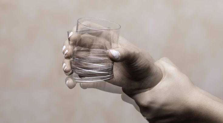 Zitternde Hand mit Glas