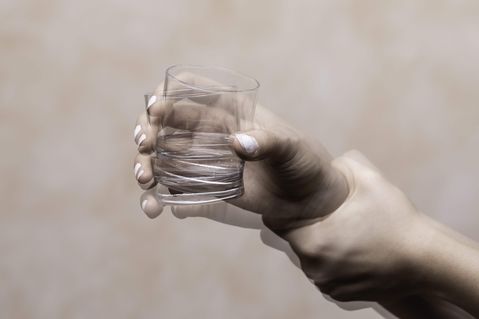 Zitternde Hand mit Glas