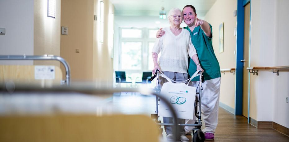 Pflegekraft mit Patientin auf dem Flur Krankenschwester mit geriatrischer Patientin